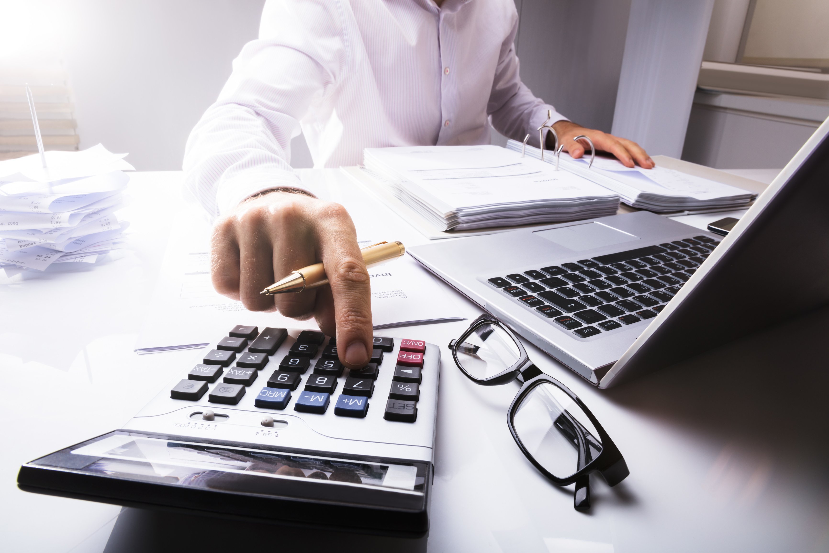 Businessperson Calculating Tax Using a Calculator